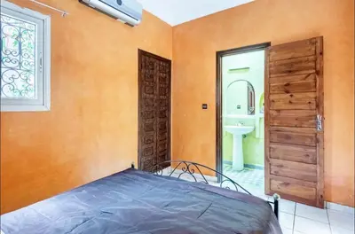 a bedroom with a bed and a bathroom at Riad Golden Palm in Marrakech