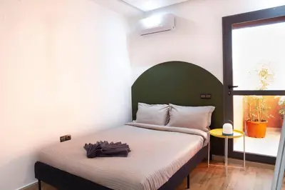 a bedroom with a bed with a green headboard at Majorelle Elegance City Center in Marrakech