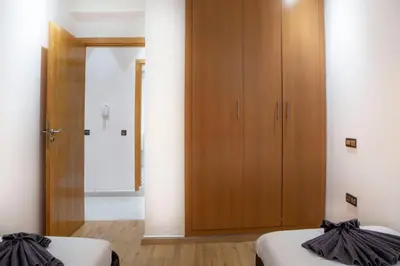 a bedroom with two beds and a wooden cabinet at Majorelle Elegance City Center in Marrakech