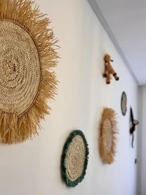 a white wall with a straw hat and a clock at Apartment JADE Palmeraie, residence with pool in Marrakech