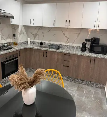 a kitchen with a table with a vase on it at Apartment JADE Palmeraie, residence with pool in Marrakech