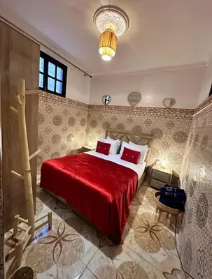 a bedroom with a large bed with red sheets at Apartment in heart of Medina in Marrakech