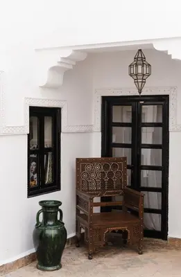 a room with a vase and a chair and a mirror at Riad Privatif avec Personnel et Services Exclusifs - Kasbah Boma Marrakech I in Marrakech
