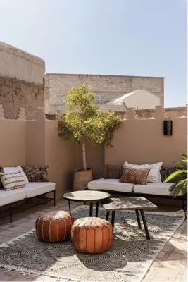 a patio with couches and tables and a tree at Riad Privatif avec Personnel et Services Exclusifs - Kasbah Boma Marrakech I in Marrakech