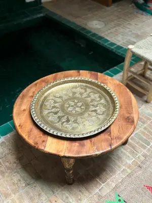 a wooden table with a plate on top of it at Riad bab Adam in Marrakech
