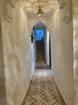 a hallway with stairs and a chandelier at Riad bab Adam in Marrakech