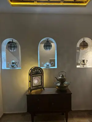 a room with three arched windows and a wooden table at Riad bab Adam in Marrakech