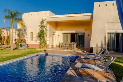 a house with a swimming pool in front of a house at Heated Pool Villa in Marrakech