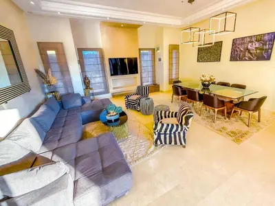 a living room with a couch and a dining room at Heated Pool Villa in Marrakech