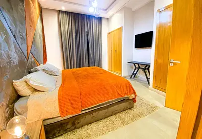 a bedroom with a bed with an orange blanket at Heated Pool Villa in Marrakech