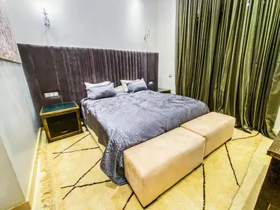 a bedroom with a large bed and a couch at Heated Pool Villa in Marrakech