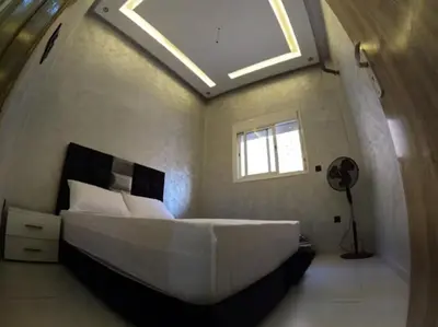 a bedroom with a large white bed with a skylight at Appartement en résidence in Marrakech