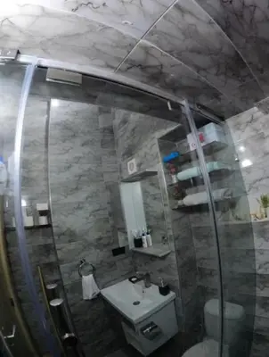 a bathroom with a shower and a sink and a mirror at Appartement en résidence in Marrakech