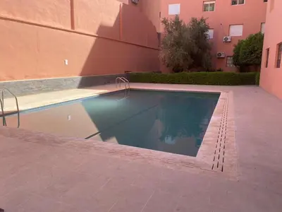 a swimming pool in front of a building at Immob in Marrakech