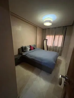 a bedroom with a bed with a blue comforter at Immob in Marrakech