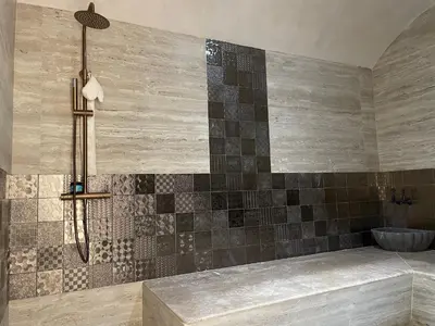 a bathroom with a shower with a tile wall at M REVASION Appartement Golf27 in Marrakech