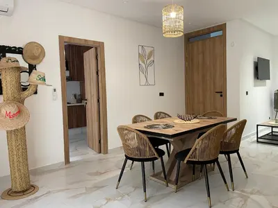 a dining room with a wooden table and chairs at M REVASION Appartement Golf27 in Marrakech
