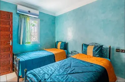 two beds in a room with blue walls at Blue Room in Marrakech