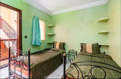 two beds in a room with green walls at Blue Room in Marrakech