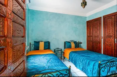two beds in a room with blue walls at Blue Room in Marrakech