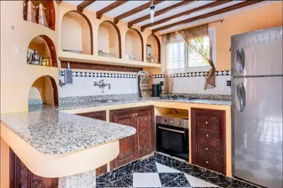 a large kitchen with a counter and a refrigerator at Blue Room in Marrakech