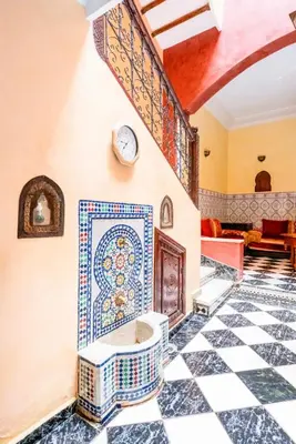 a room with a tile wall with a clock on the wall at Blue Room in Marrakech