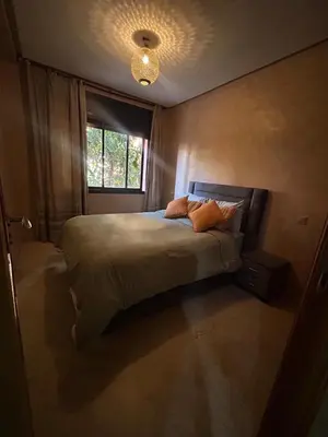a bedroom with a large bed with a window at Appartements de vacances in Marrakech