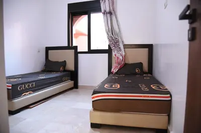 two beds in a room with a window at Premium village c1866 in Marrakech
