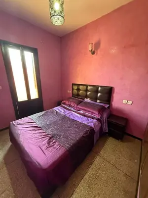 a bedroom with a bed with purple sheets and a window at شقة بمدينة مراكش بقرب جميع المرافق in Marrakech
