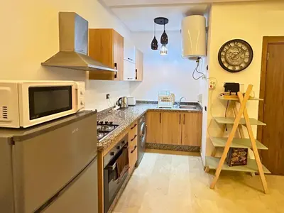 a kitchen with a microwave and a stove top oven at Le Coup de cœur de Guéliz avec Piscine et Parking in Marrakech