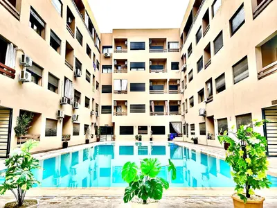 an apartment building with a swimming pool in front of it at Le Coup de cœur de Guéliz avec Piscine et Parking in Marrakech