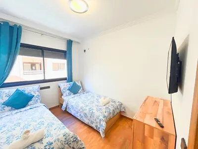 a small room with two beds and a television at Le Coup de cœur de Guéliz avec Piscine et Parking in Marrakech
