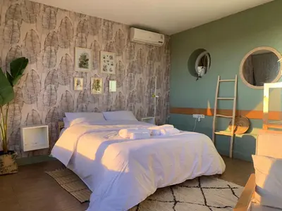 a bedroom with a large bed and a wall at Cozy & Bright Apartment with a Panoramic View in Marrakech