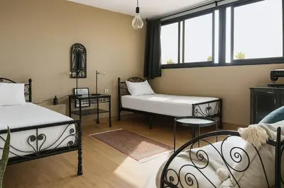 a living room with two beds and a table at Cozy & Bright Apartment with a Panoramic View in Marrakech