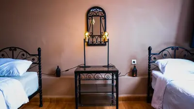 a bedroom with two beds and a mirror on a table at Cozy & Bright Apartment with a Panoramic View in Marrakech