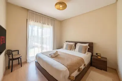 a bedroom with a large bed and a window at Trois chambres et Jardin Prive a Prestigia in Marrakech