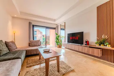 a living room with a couch and a tv at Luxury and Serenity at Noria Golf and Pool in Marrakech