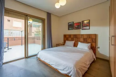 a bedroom with a bed and a large window at Spacious Luxury Apartment with Heated Pool Center in Marrakech