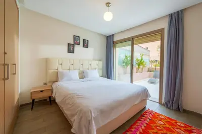 a bedroom with a large bed and a large window at Spacious Luxury Apartment with Heated Pool Center in Marrakech