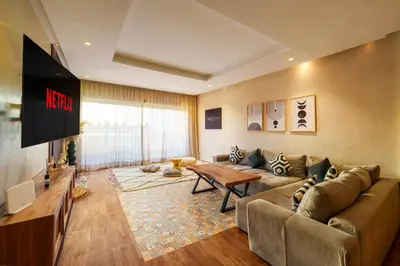 a living room with a couch and a tv at Spacious Luxury Apartment with Heated Pool Center in Marrakech