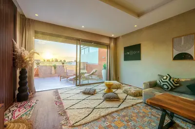 a living room with a couch and a large window at Spacious Luxury Apartment with Heated Pool Center in Marrakech
