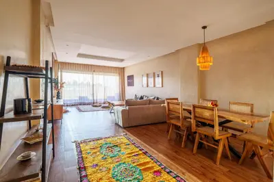 a living room with a table and a couch at Spacious Luxury Apartment with Heated Pool Center in Marrakech