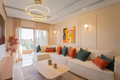 a living room with a white couch with colorful pillows at Orange apartment in Marrakech