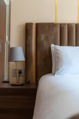 a bed with a white pillow and a lamp on a table at Orange apartment in Marrakech