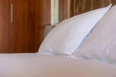 a bed with white sheets and pillows at Orange apartment in Marrakech