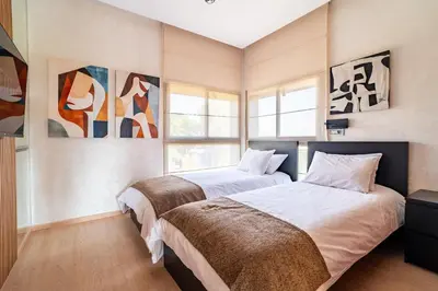 two beds in a bedroom with paintings on the walls at Orange apartment in Marrakech