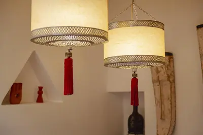 two lights hanging from a wall with red tassels at Riad Amaya in Marrakech