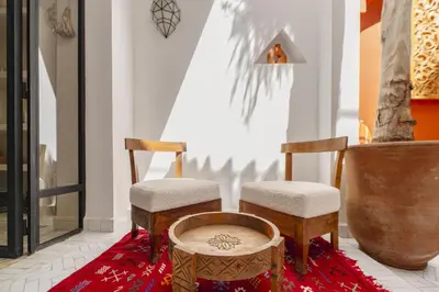 two chairs and a table on a red rug at Riad Amaya in Marrakech
