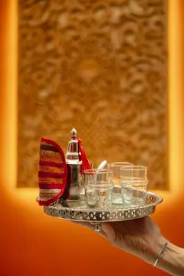 a person holding a tray with glasses on it at Riad Amaya in Marrakech