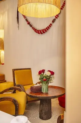 a living room with a table with a vase of flowers at Riad Amaya in Marrakech